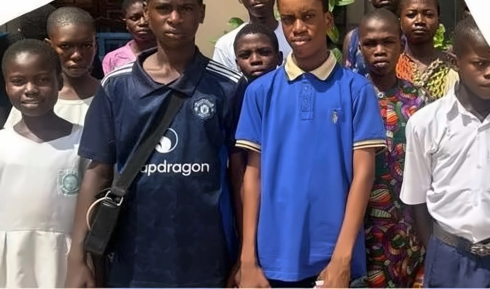 A group of Edu-Kids beneficiaries standing together outside their school
