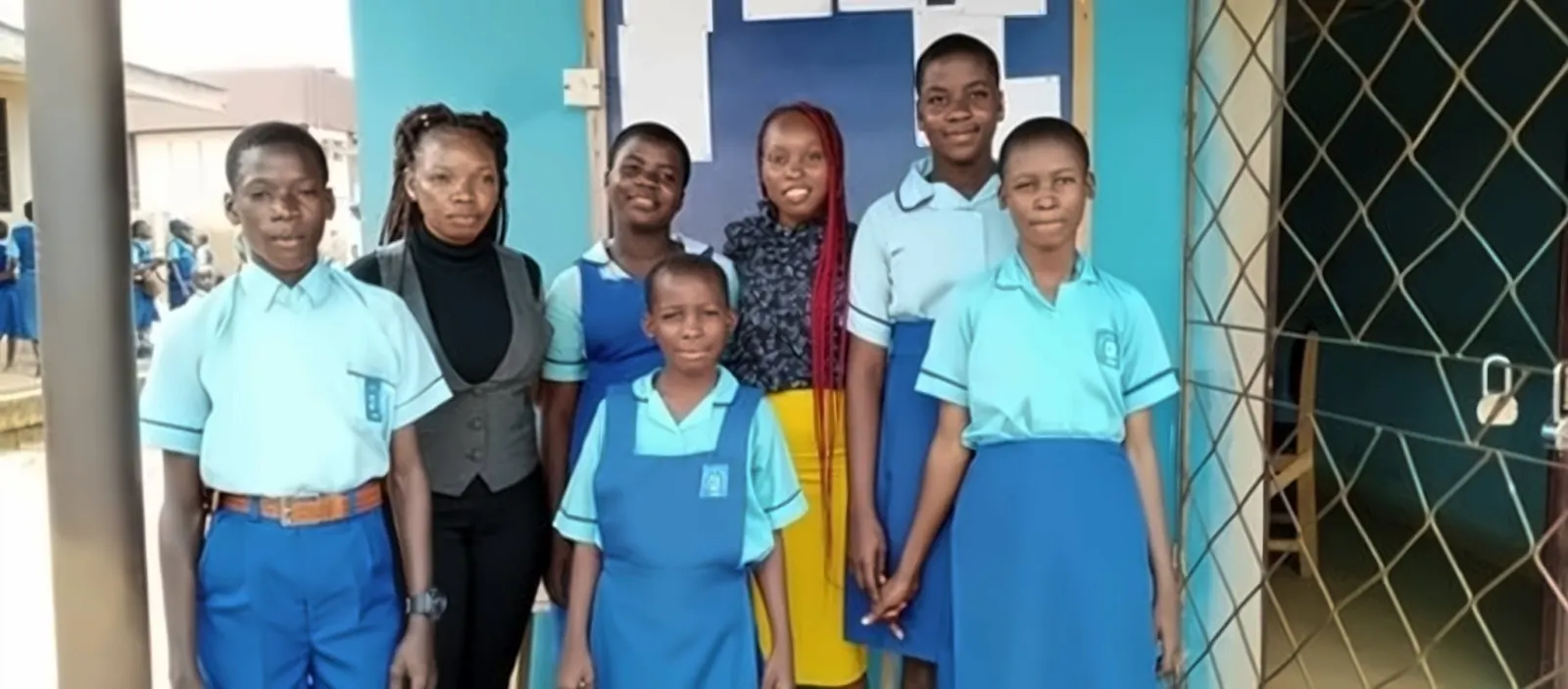 Volunteers with students in blue uniforms