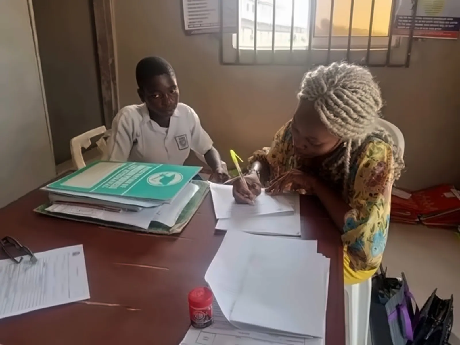 A foundation volunteer working through paperwork one-to-one with a student