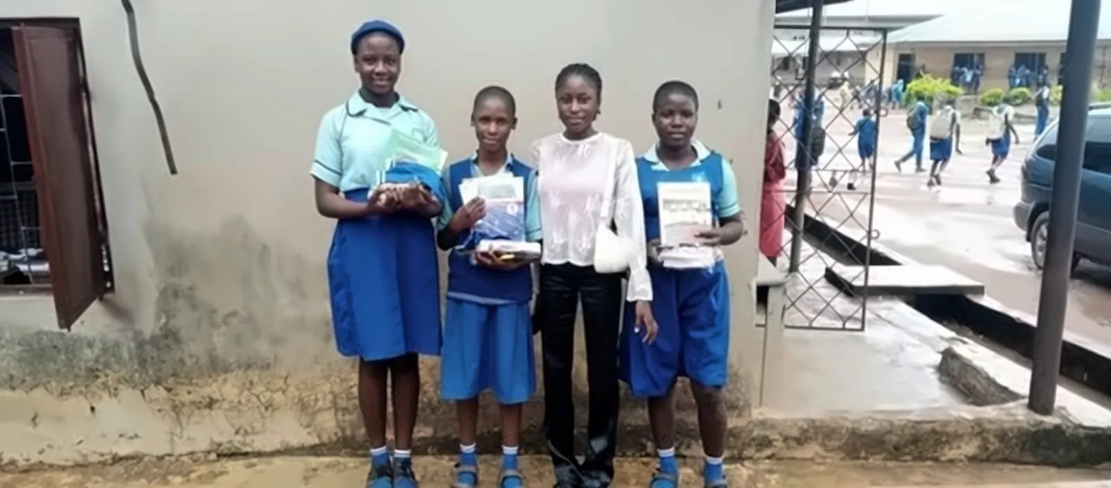 Students in blue uniforms holding textbooks