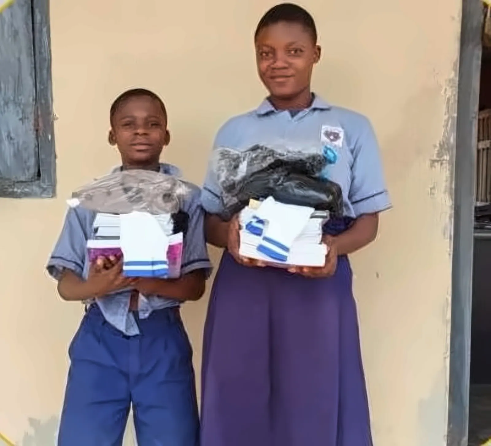 Two Student Support Programme beneficiaries holding their new school supplies